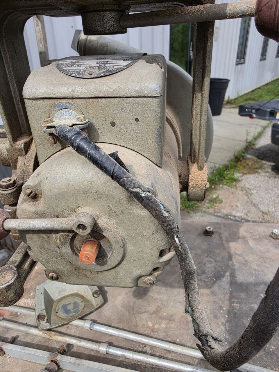 Motor and nameplate with the original cloth-covered cord frayed and split along its length