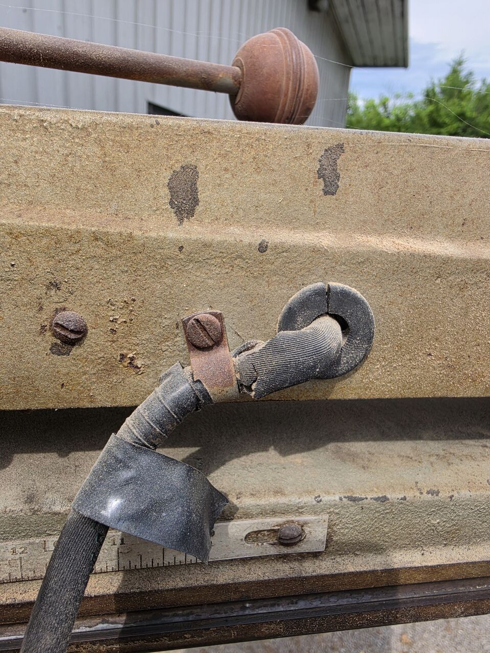 Cord entering the arm through a cracked rubber grommet, with a strip of electrical tape on the cord