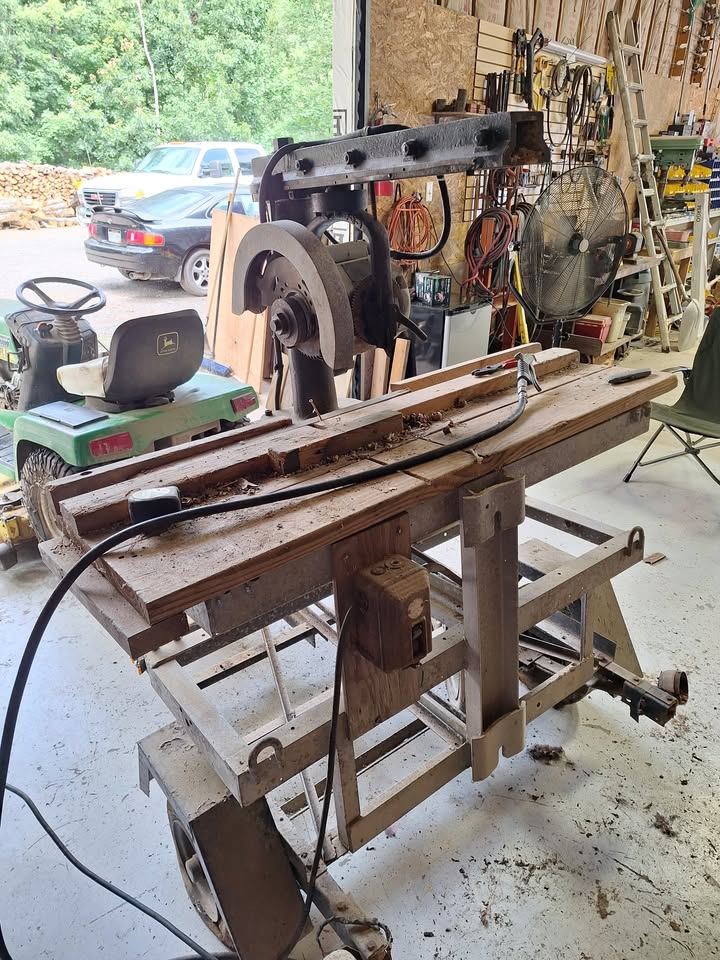 The saw mounted on its rolling stand, front view with the shop doors open