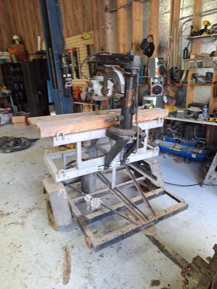 The saw on its rolling stand, angled view showing the scissor-lift base